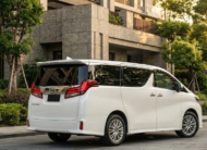 2023 Toyota Alphard luxury minivan in white parked in modern city